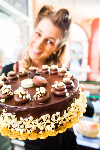 Női baker bemutató torta, cukrászda — Stock Fotó