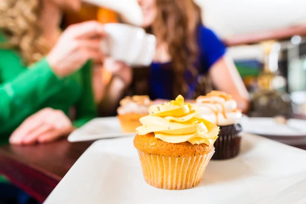 Frauen essen Muffins beim Kaffeetrinken — Stockfoto
