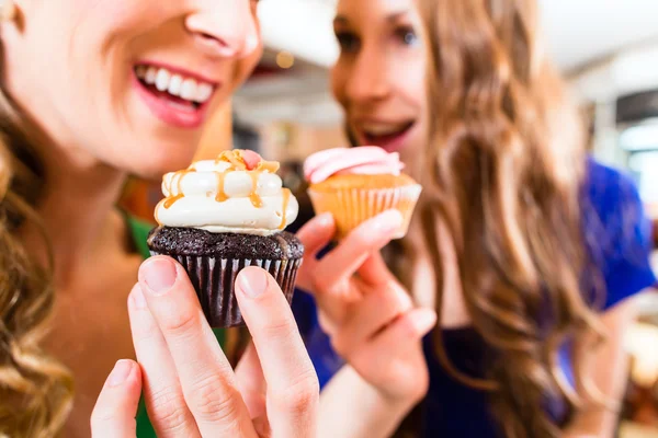 Wanita makan muffin sementara kopi minum — Stok Foto