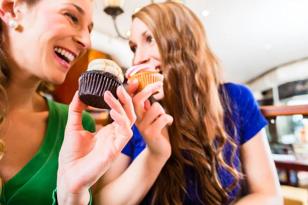 Women eating muffins while coffee drinking — Stock Photo, Image