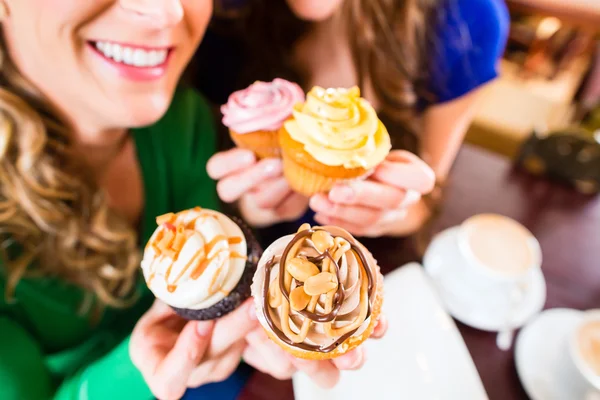 Mujeres comiendo magdalenas mientras beben café — Foto de Stock