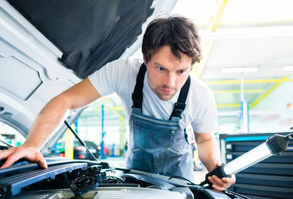 Mécanicien automobile travaillant dans l'atelier de service de voiture — Photo