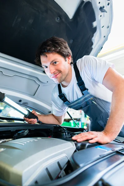 Mécanicien automobile travaillant dans l'atelier de service de voiture — Photo