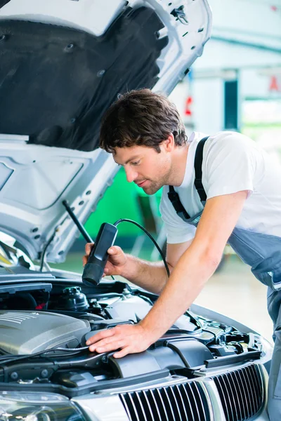 Mecánico con herramienta de diagnóstico en taller de automóviles —  Fotos de Stock