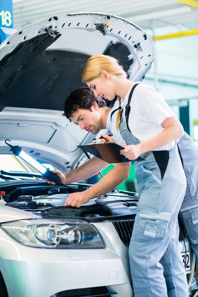 Equipo mecánico trabajando en taller de coches —  Fotos de Stock