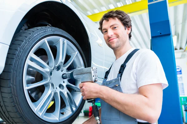 Changement de pneu mécanicien en atelier de voiture — Photo