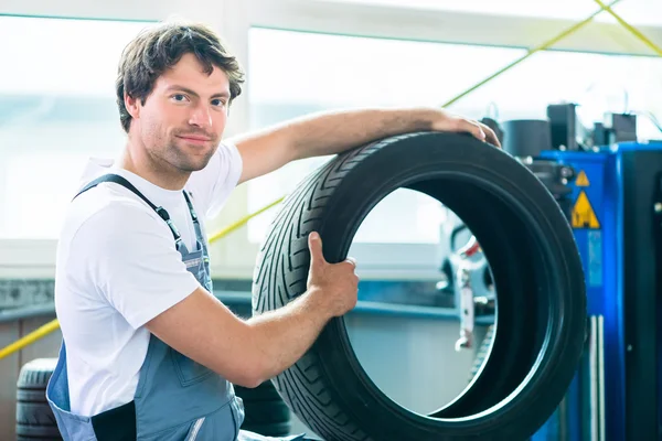 Auto mecánico cambio de neumáticos en taller de coches —  Fotos de Stock