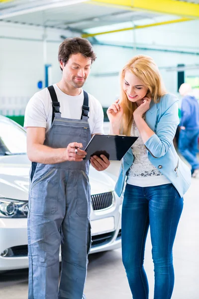 Werkstattmechaniker übergibt Auto an Kunden — Stockfoto