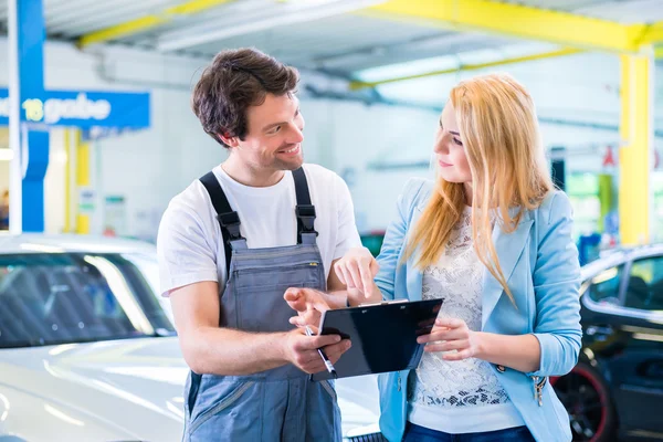 Werkstattmechaniker übergibt Auto an Kunden — Stockfoto