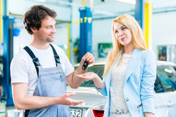 Werkstattmechaniker übergibt Auto an Kunden — Stockfoto