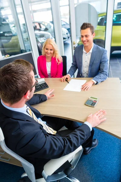 Couple negotiating sale contact for car — Stock Photo, Image