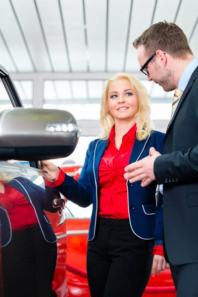 Frau schaut sich Auto in Autohaus an — Stockfoto