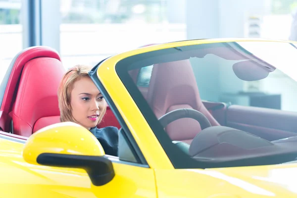 Mulher asiática testando novo carro esporte — Fotografia de Stock