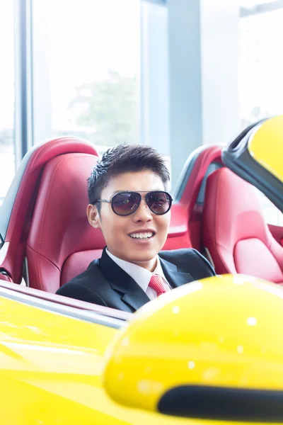 アジアの男は新しいスポーツカーをテスト — ストック写真