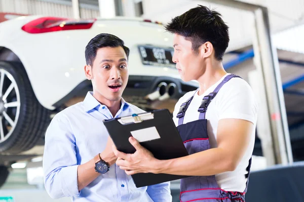 Carro mecânico e cliente em oficina de automóveis — Fotografia de Stock