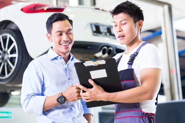 Carro mecânico e cliente em oficina de automóveis — Fotografia de Stock