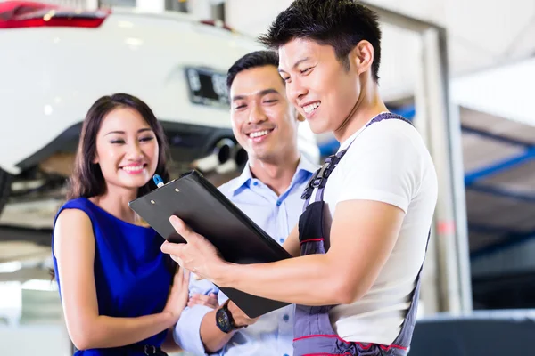 Auto-mechanic en Aziatische klant paar — Stockfoto