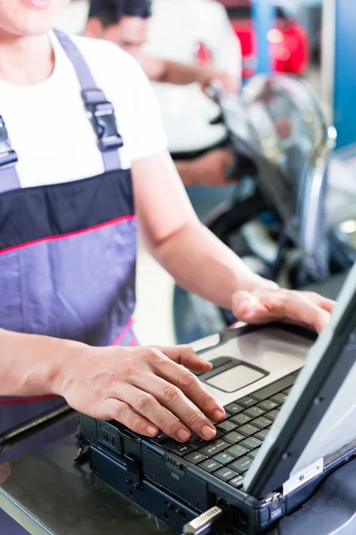 Car mechanic with diagnosis tool in auto workshop — Stock Photo, Image