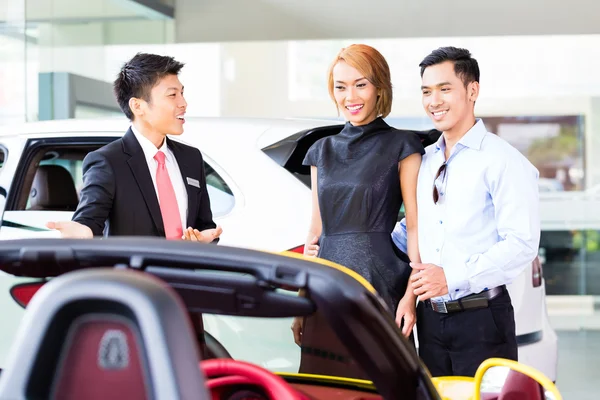 Pareja asiática comprando coche en concesionario — Foto de Stock