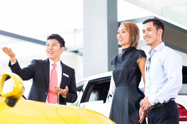 Pareja asiática comprando coche en concesionario — Foto de Stock