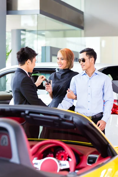 Pareja asiática comprando coche en concesionario — Foto de Stock