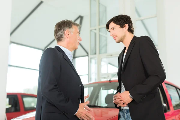 Concessionnaire et homme avec auto dans le concessionnaire automobile — Photo