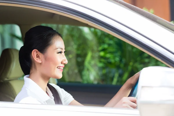 Mujer asiática conduciendo coche nuevo — Foto de Stock