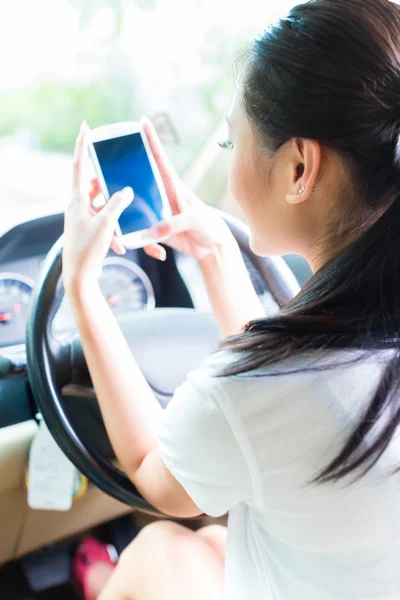 Ασιατική γυναίκα γραπτών μηνυμάτων κατά την οδήγηση αυτοκινήτου — Φωτογραφία Αρχείου