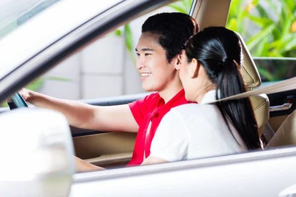 Asian couple driving new car — Stock Photo, Image