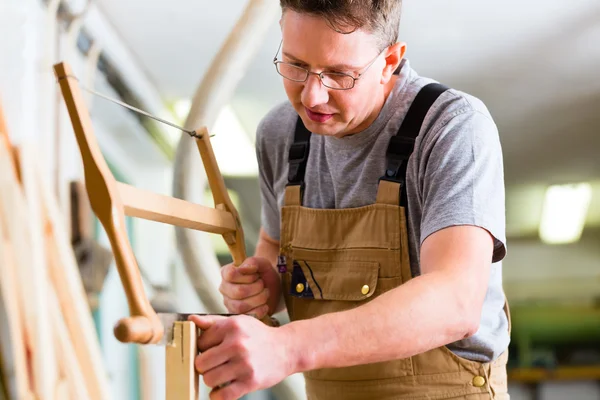 Carpinteiro usando serra manual — Fotografia de Stock
