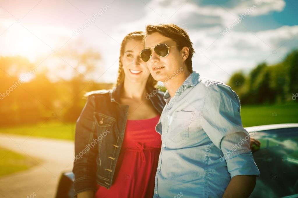 couple with cabriolet car in spring on day trip