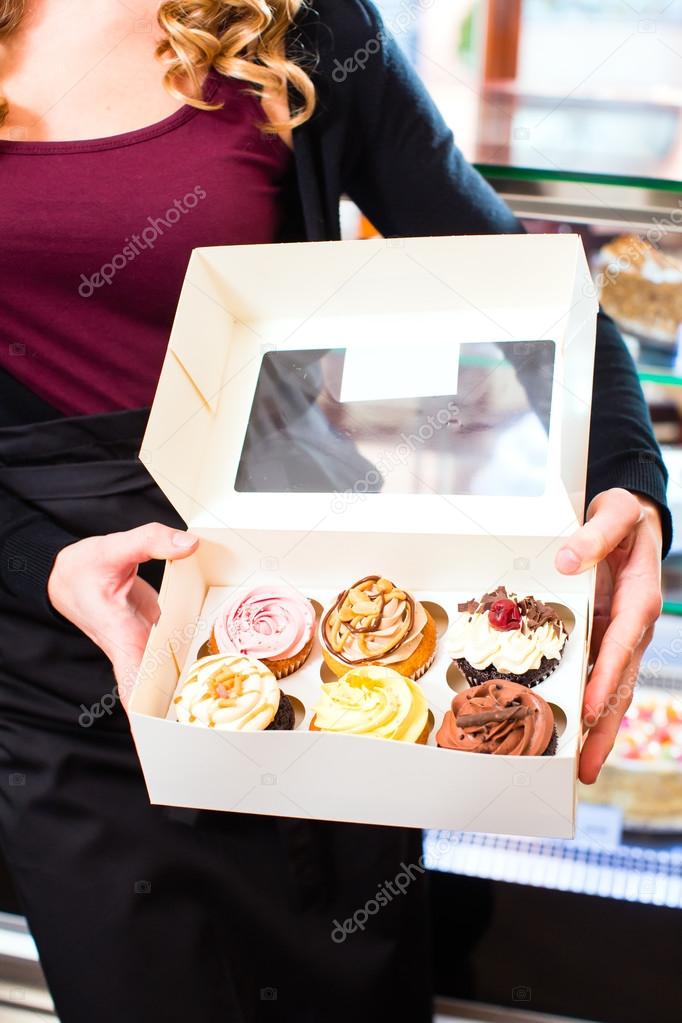 Woman presenting takeaway boxes of confectionery