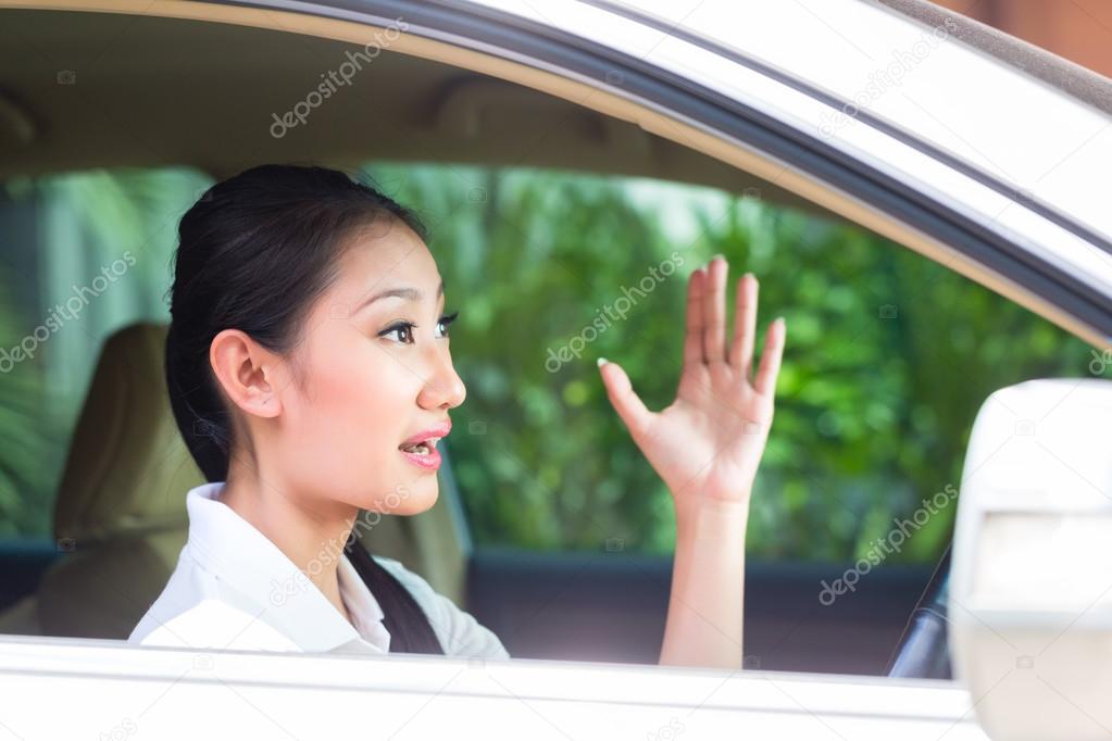 Asian woman driving new car