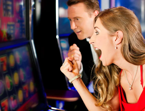Paar im Casino am Spielautomaten — Stockfoto