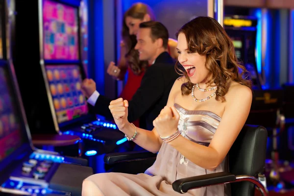 Freunde im Casino am Spielautomaten — Stockfoto