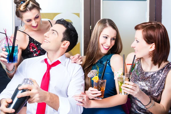 Amigos comemorando com barman em bar de coquetéis — Fotografia de Stock