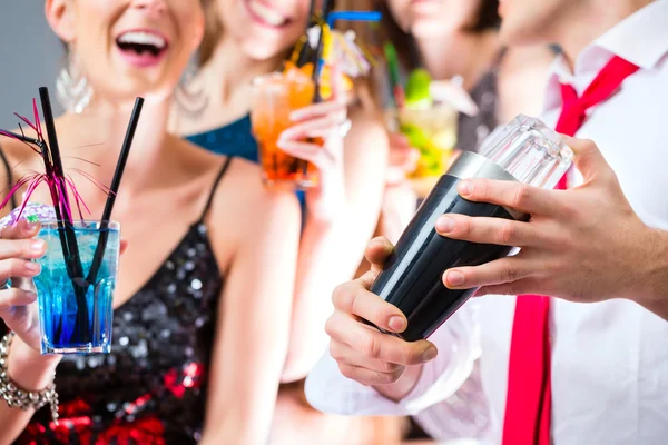 Girls celebrating with barkeeper in cocktail bar — Stock Photo, Image