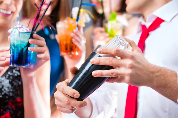 Girls celebrating with barkeeper in cocktail bar — Stock Photo, Image