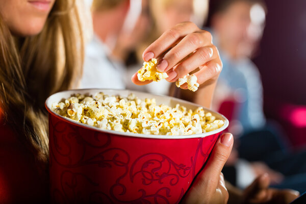 Girl eating popcorn in cinema