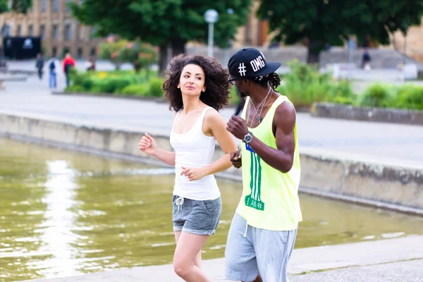 Africano casal correndo através do centro da cidade — Fotografia de Stock