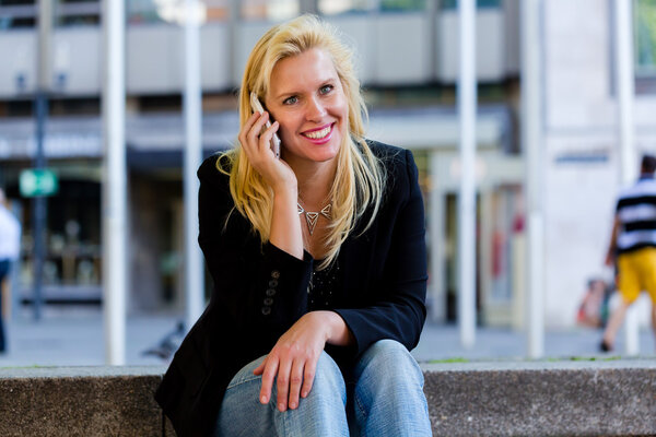 Женщина с телефоном покупки в городе
