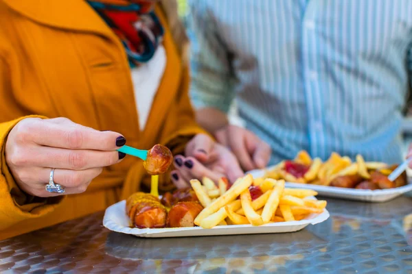 Par äta tyska Currywurst i monter — Stockfoto