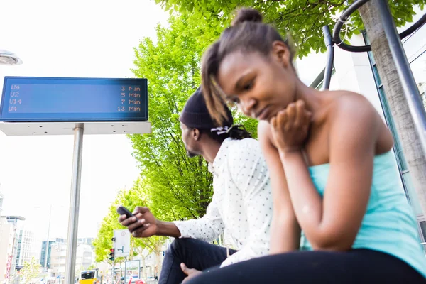 Pareja africana esperando en la estación de autobuses —  Fotos de Stock