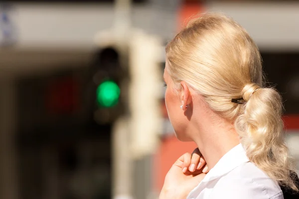 Kvinna som står vid grönt trafikljus — Stockfoto