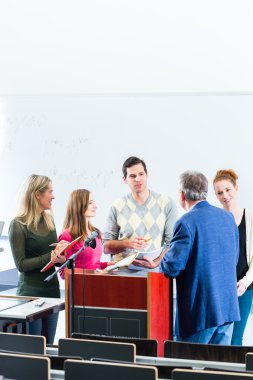 Profesör üniversite oditoryumunda soran öğrenciler
