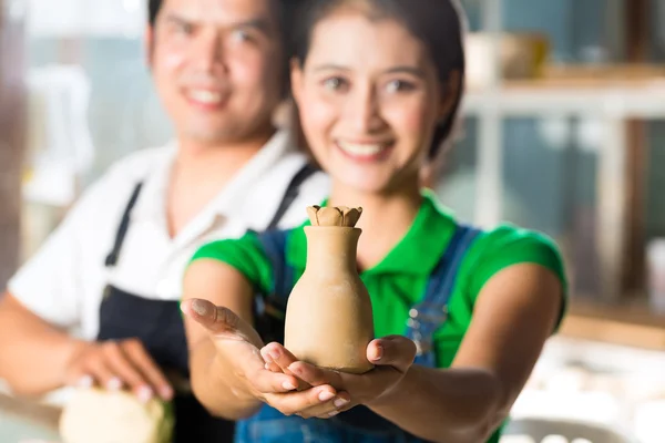 Asians with handmade pottery in clay studio — Stock Photo, Image
