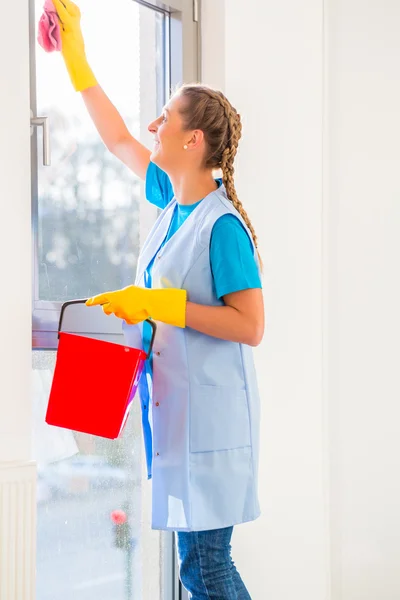 Cleaning lady met doek ter venster — Stockfoto