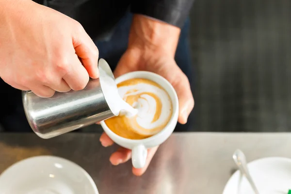 Barista maken cappuccino in zijn coffeeshop — Stockfoto