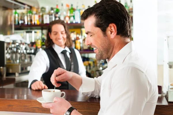 Barista with client in his cafe or coffeeshop — Stock Photo, Image