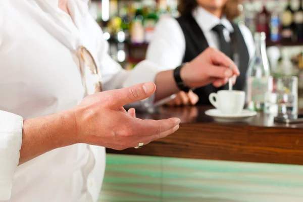 Barista com cliente em seu café ou coffeeshop — Fotografia de Stock